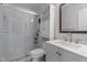 Bright bathroom featuring tiled shower with glass doors, white vanity, and built-in storage shelves at 8333 Bellingham Cir, Raleigh, NC 27615