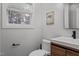 Modern half bathroom with a floating vanity, an updated commode, a window, and a wood accent wall at 8333 Bellingham Cir, Raleigh, NC 27615