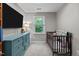 Bedroom featuring a crib, dresser, window, and decorative touches at 8333 Bellingham Cir, Raleigh, NC 27615