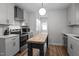 Bright kitchen featuring white subway tile, stainless steel appliances, white cabinets, and a butcher block island with wood flooring at 8333 Bellingham Cir, Raleigh, NC 27615