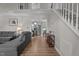 Bright, open living room with hardwood floors, a staircase, and views of the kitchen and a comfortable gray sofa at 8333 Bellingham Cir, Raleigh, NC 27615