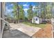 Spacious backyard with concrete patio, fire pit, privacy fence, mature trees, and white storage shed at 8721 Attingham Dr, Raleigh, NC 27615