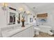 Bathroom featuring double sink vanity with large mirror and soaking tub under a window with woven shades at 8721 Attingham Dr, Raleigh, NC 27615