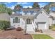 Charming two-story home features a white painted brick exterior, gabled roof, and manicured front yard at 8721 Attingham Dr, Raleigh, NC 27615