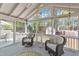 Screened-in porch featuring cozy seating, vaulted ceiling, and bright views of the outdoor landscape at 8721 Attingham Dr, Raleigh, NC 27615