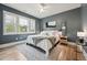 This bedroom has a ceiling fan, a gray accent wall, and light colored wood floors at 904 Coral Bell Dr, Wake Forest, NC 27587