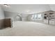 Bright bonus room with carpet, windows, staircase, and built-in shelving at 904 Coral Bell Dr, Wake Forest, NC 27587
