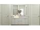 Elegant bathroom featuring a double vanity with white cabinets and a large mirror at 92 Glencoe Ln, Zebulon, NC 27597