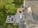 Aerial view of a backyard featuring a dining area, fire pit, mature trees, and lush lawn at 1001 Manchester Dr, Raleigh, NC 27609
