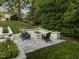 Outdoor living space with a cozy fire pit surrounded by seating and lush landscaping at 1001 Manchester Dr, Raleigh, NC 27609