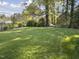 Large backyard with a well-maintained lawn, mature trees and landscaping at 1001 Manchester Dr, Raleigh, NC 27609