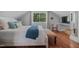Bright bedroom featuring a bed with white bedding, blue throw blanket and a sunlit window at 1001 Manchester Dr, Raleigh, NC 27609