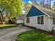 Charming home showcasing blue and white tones and a welcoming entrance with a long drive surrounded by lush greenery at 1001 Manchester Dr, Raleigh, NC 27609