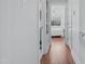 Hallway leading to a bedroom with hardwood floors, crisp white walls, and a window with natural light at 1001 Manchester Dr, Raleigh, NC 27609