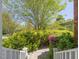 Landscaped backyard featuring mature trees and garden, creating a serene and private outdoor oasis perfect for relaxation at 1008 Maduro Ct, Zebulon, NC 27597