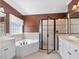Bright bathroom features a soaking tub, glass enclosed shower, and double sink vanity at 1008 Maduro Ct, Zebulon, NC 27597