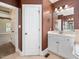 A bathroom features a cream tile floor, a white vanity, and an entrance to the bedroom at 1008 Maduro Ct, Zebulon, NC 27597