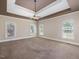 Spacious main bedroom with tray ceiling, fan, carpet flooring, and lots of natural light at 1008 Maduro Ct, Zebulon, NC 27597