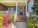 Inviting front porch with brick steps and colorful floral accents at 1008 Maduro Ct, Zebulon, NC 27597