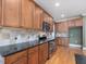 A spacious kitchen with granite countertops, wood cabinets, stainless appliances, and tile backsplash at 1008 Maduro Ct, Zebulon, NC 27597