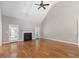 Spacious living room featuring vaulted ceilings, hardwood floors, fireplace, and a ceiling fan that provide comfort and style at 1008 Maduro Ct, Zebulon, NC 27597
