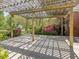 Outdoor covered patio with wooden pergola offering shade and view of lush landscaping and backyard at 1008 Maduro Ct, Zebulon, NC 27597
