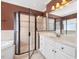 The bathroom shower has cream colored tile, a shower head, and a glass door at 1008 Maduro Ct, Zebulon, NC 27597