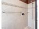 Close up of a bathroom shower with cream colored tile, a shower head, and a safety bar at 1008 Maduro Ct, Zebulon, NC 27597