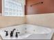 The bathroom features a large white soaking tub near a window with privacy glass at 1008 Maduro Ct, Zebulon, NC 27597