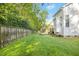 Expansive lawn with wooden fence and deck leading to the charming two-story home at 102 Cockleshell Ct, Cary, NC 27513