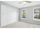 Neutral bedroom featuring a double door closet and two windows at 102 Cockleshell Ct, Cary, NC 27513