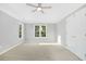 Spacious primary bedroom with a tray ceiling, carpet, and many windows at 102 Cockleshell Ct, Cary, NC 27513