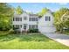 Classic two-story white home with black shutters, complemented by lush green lawn and mature trees at 102 Cockleshell Ct, Cary, NC 27513