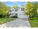 Inviting two-story residence with a spacious driveway leading to the attached garage, nestled among mature trees at 102 Cockleshell Ct, Cary, NC 27513