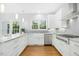 Bright kitchen features white cabinets, marble countertops, and stainless steel appliances at 102 Cockleshell Ct, Cary, NC 27513