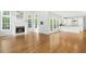 Open-concept living area features hardwood floors, a fireplace, many windows and white kitchen in background at 102 Cockleshell Ct, Cary, NC 27513