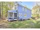 Back exterior of a two-story home featuring a screened in porch, blue siding, and well maintained landscaping at 107 Hillcrest Ave # C And D, Carrboro, NC 27510