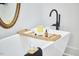 Modern bathroom featuring a soaking tub with stylish faucet, a tray with bath essentials, and elegant decor at 107 Hillcrest Ave # C And D, Carrboro, NC 27510