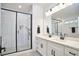 Modern bathroom with dual vanity, sleek black fixtures, and a glass-enclosed shower with pebble tile flooring at 107 Hillcrest Ave # C And D, Carrboro, NC 27510