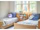 Cozy ' bedroom with two twin beds, a bookshelf filled with books, and large windows providing natural light at 107 Hillcrest Ave # C And D, Carrboro, NC 27510