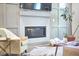 Close up on living room fireplace featuring hexagon tile, hardwood floors, a comfortable chair and modern accents at 107 Hillcrest Ave # C And D, Carrboro, NC 27510