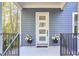 A welcoming front porch with modern white door, black railings, and potted flowers, inviting you into this beautiful home at 107 Hillcrest Ave # C And D, Carrboro, NC 27510