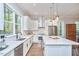 Bright kitchen features white cabinets, stainless appliances, large island with seating and view to the backyard at 107 Hillcrest Ave # C And D, Carrboro, NC 27510