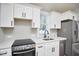 Modern kitchen features stainless steel appliances, white cabinets, and quartz countertops at 107 Hillcrest Ave # C And D, Carrboro, NC 27510
