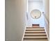 Bright staircase featuring light wood stairs, a round mirror, and white walls that create a modern and inviting space at 107 Hillcrest Ave # C And D, Carrboro, NC 27510