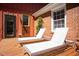 Cozy backyard deck featuring lounge chairs, a brick wall, and a glass door, perfect for relaxation at 1109 Huntington Ave, Durham, NC 27707
