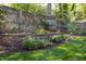 Beautiful backyard with retaining wall, flower beds, wooden fence, and lush green lawn at 1109 Huntington Ave, Durham, NC 27707