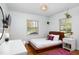 Bright bedroom with a wooden bed frame, white linens, desk, and bright windows at 1109 Huntington Ave, Durham, NC 27707