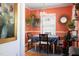 Charming dining room with coral walls, unique light fixture, and a view into the kitchen at 1109 Huntington Ave, Durham, NC 27707