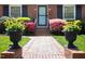 Inviting brick pathway leading to the home with well-placed potted plants and manicured bushes at 1109 Huntington Ave, Durham, NC 27707